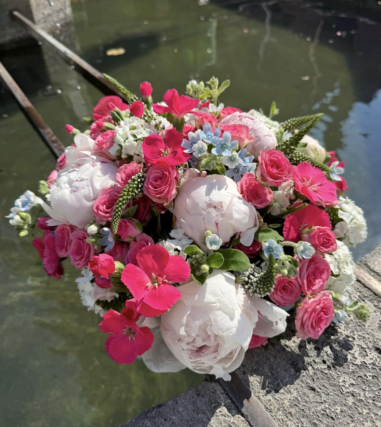 Von Hand gebundener Strauß mit rosa Rosen und weißen Pfingstrosen