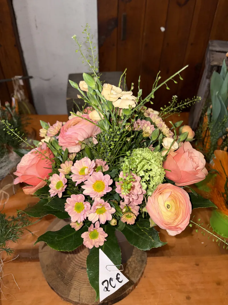 Handgebundener Strauß mit orangefarbenen Rosen, rosa Blüten und feinem Grün in Friesenheim
